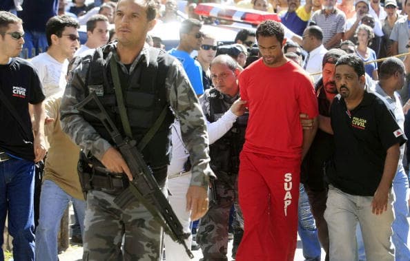 Brazilian footballer Bruno Fernandes de Souza (in red) is taken under custody to the presidium of Belo Horizonte, Brazil, on July 9, 2010. De Sousa, a star goalkeeper for the popular Brazilian club Flamengo, surrendered to police Wednesday to face questioning in connection with the disappearance of his ex-girlfriend, officials said. AFP PHOTO/Domingos Peixoto/Agência o Globo- BRAZIL OUT (Photo credit should read DOMINGOS PEIXOTO/AFP/Getty Images)