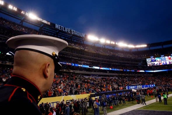 Un integrante la Marina de los Estados Unidos observa el calentamiento de los jugadores.