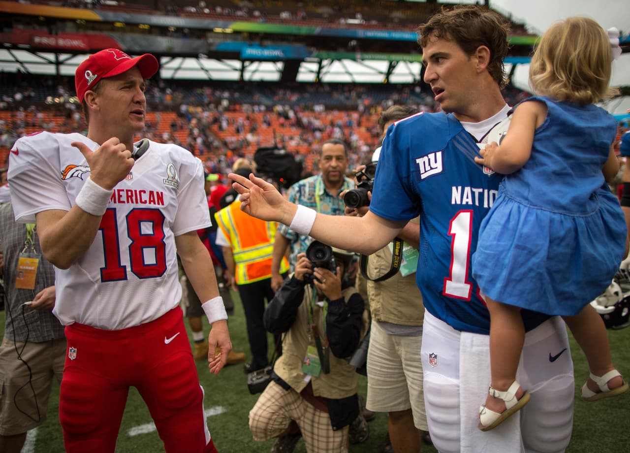 HONOLULU, HI - JANUARY 27: Peyton Manning #18 of the AFC's Denver Broncos talks with brother, Eli Manning #10 of the NFC's New York Giants after the conclusion of the 2013 AFC-NFC Pro Bowl on January 27 , 2013 at Aloha Stadium in Honolulu, Hawaii. (Photo by Kent Nishimura/Getty Images)