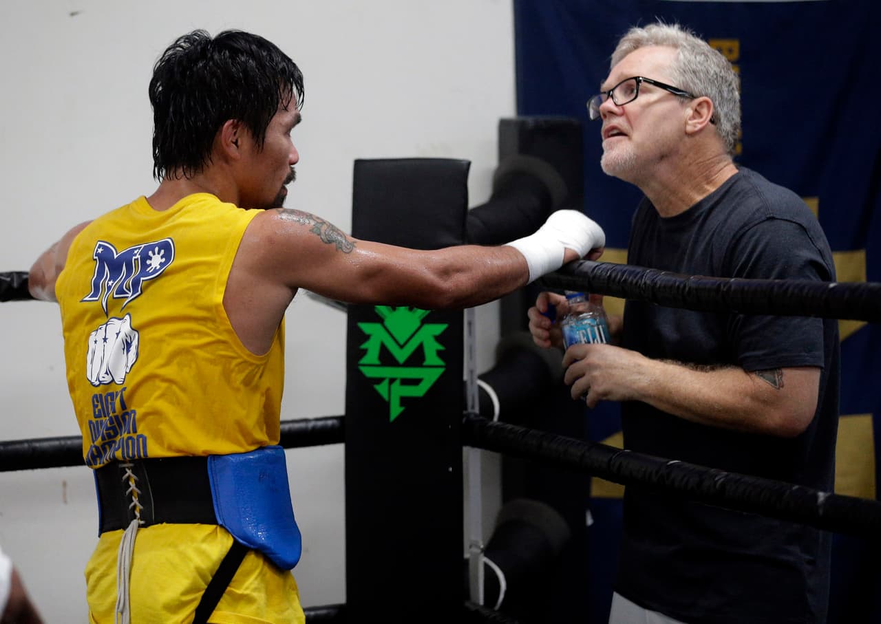 In this Monday, April 4, 2016, photo, boxer Manny Pacquiao, of the Philippines works out with trainer Freddie Roach in front of reporters and photographers at the Wild Card gym in Los Angeles. Pacquiao is scheduled to fight Timothy Bradley in Las Vegas on Saturday, April 9. (AP Photo/Nick Ut)