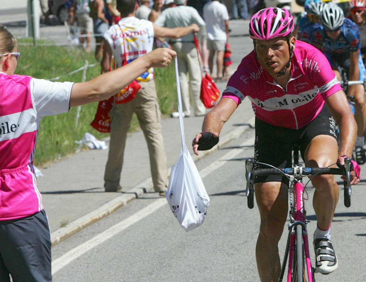 ULRICHEN, SWITZERLAND: Germany's Jan Ullrich (Team T-Mobile/Ger) grabs a bag during the last stage of the 69th "Tour de Suisse" cycling race, around Ulrichen, 19 June 2005. Spain's Aitor Gonzalez (Team Euskaltel/Spa) won the race, Australia's Michael Rogers (Team Quickstep/Bel) finished second, and Germany's Jan Ullrich (Team T-Mobile/Ger) third. AFP PHOTO DAMIEN MEYER (Photo credit should read DAMIEN MEYER/AFP/Getty Images)