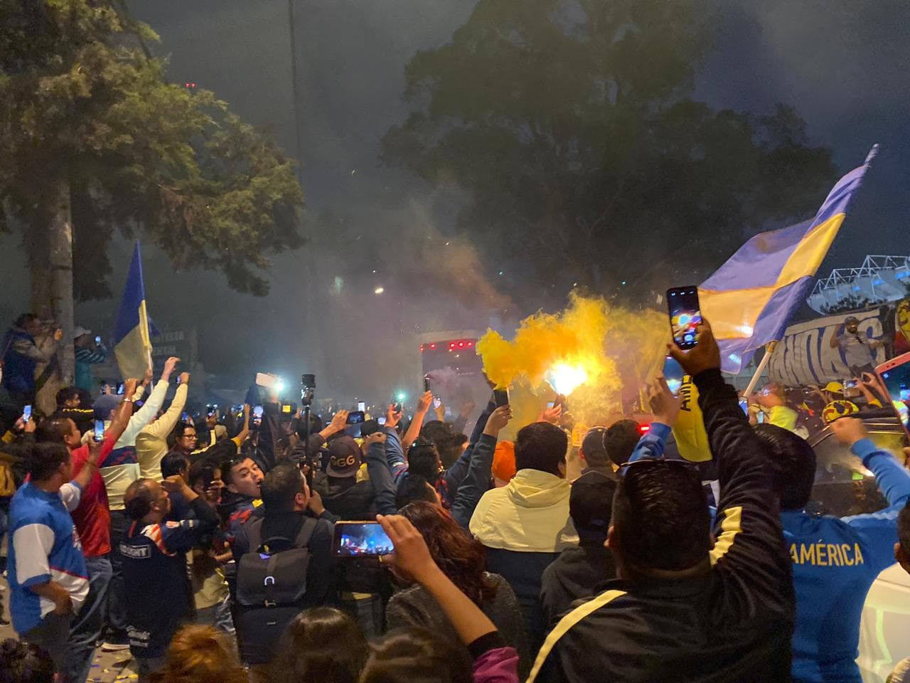 ¡Gran recibimiento al América! La afición le muestra el apoyo a su equipo con cantos, banderas y bengalas a su llegada al Estadio Azteca.