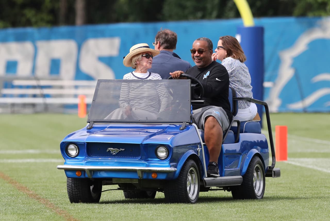 En el carrito de golf, adelante y a la izquierda, con sombrero, viaja la propietaria y presidente del equipo de los Lions, Martha Firestone Ford.