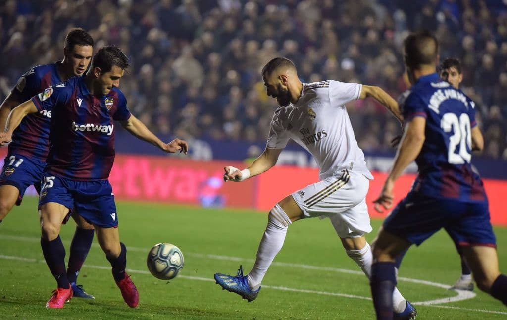 Karim Benzema trata de sacar el disparo entre tres jugadores rivales y consigue el tiro de esquina.