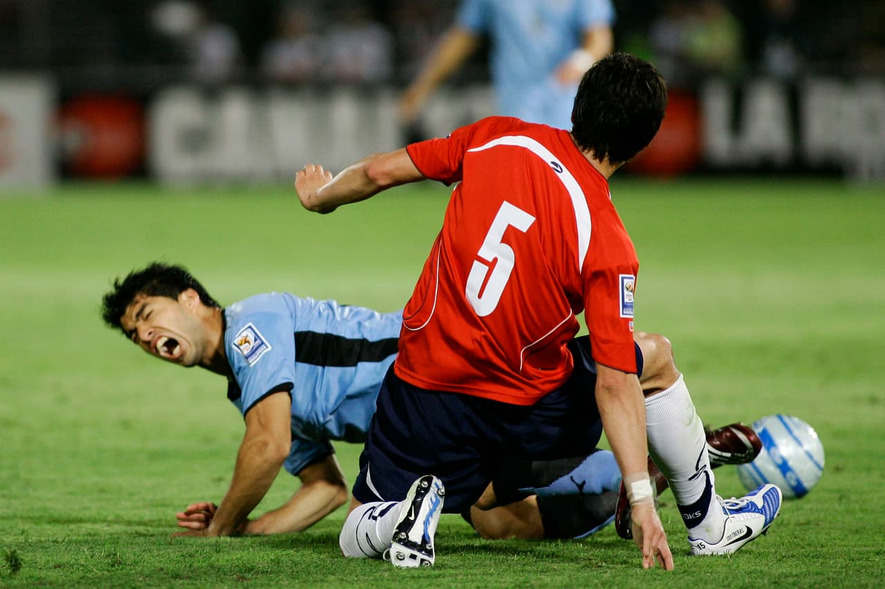 SANTIAGO, CHILE - APRIL 01: Uruguay's Luis Suarez (L) vies for the ball with Chile's Pablo Contreras during their 2010 FIFA World Cup Qualifier at the National Stadium on April 1, 2009 in Santiago, Chile. The match ended in a 0-0 draw. (Photo by Marcelo Hernandez/LatinContent/Getty Images)