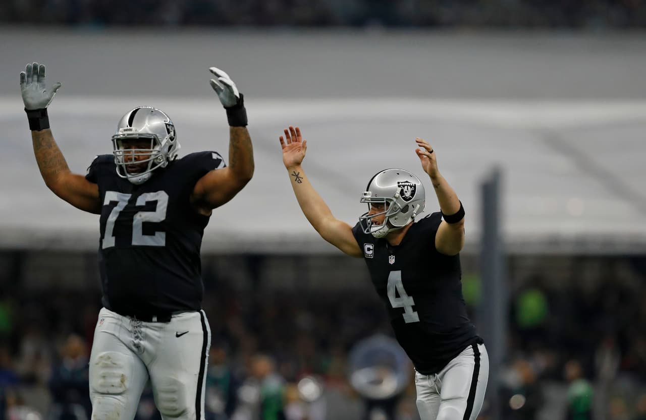 Oakland Raiders quarterback Derek Carr (4) celebrates after throwing a touchdown pass during an NFL football game against the Houston Texans on Monday, Nov. 21, 2016 in Mexico City. (Aaron M. Sprecher via AP)