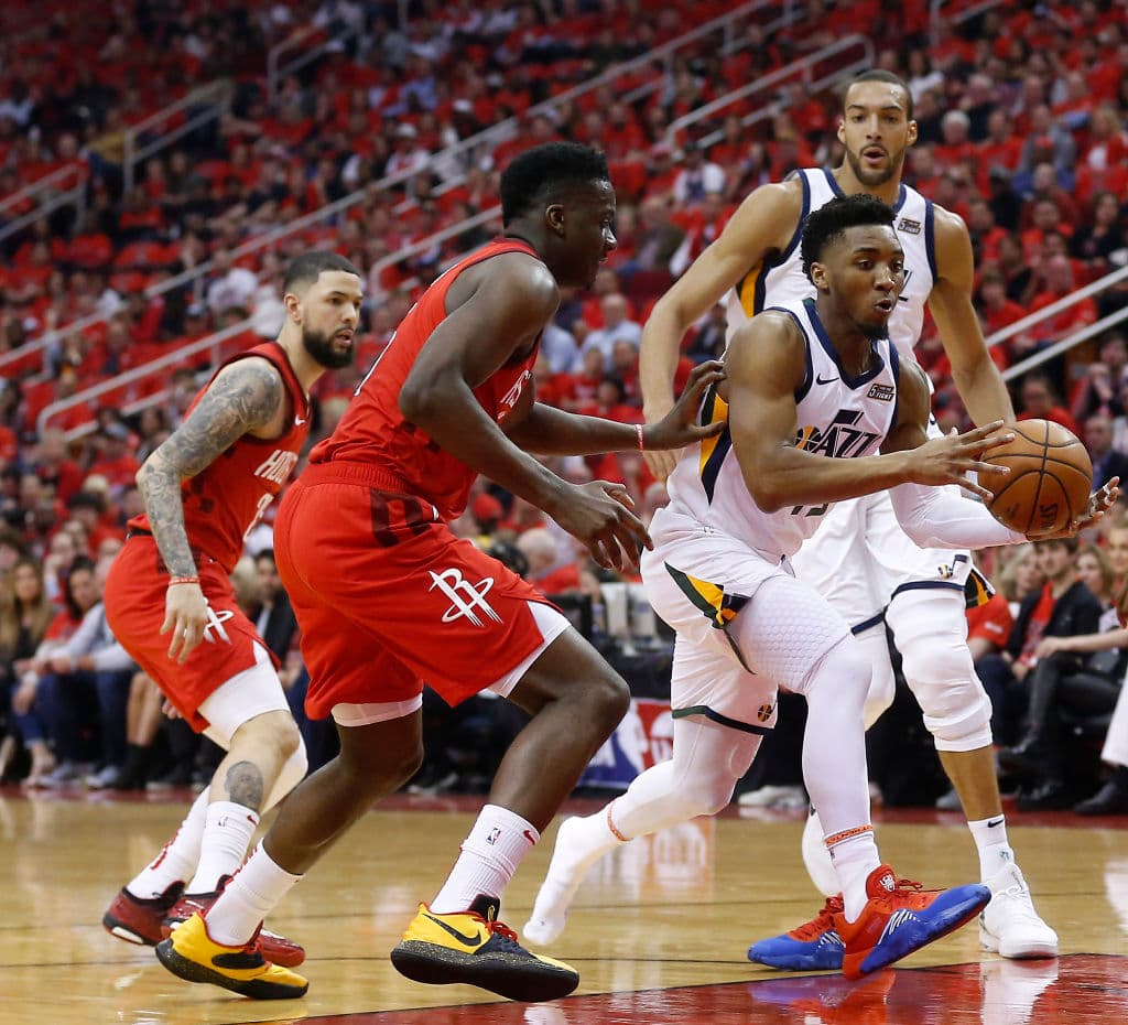 HOUSTON, TEXAS - APRIL 14: Donovan Mitchell #45 of the Utah Jazz attempts tp drive through Clint Capela #15 of the Houston Rockets and Danuel House Jr. #4 in the first half during Game One of the first round of the 2019 NBA Western Conference Playoffs between the Houston Rockets and the Utah Jazz at Toyota Center on April 14, 2019 in Houston, Texas. NOTE TO USER: User expressly acknowledges and agrees that, by downloading and or using this photograph, User is consenting to the terms and conditions of the Getty Images License Agreement. (Photo by Bob Levey/Getty Images)