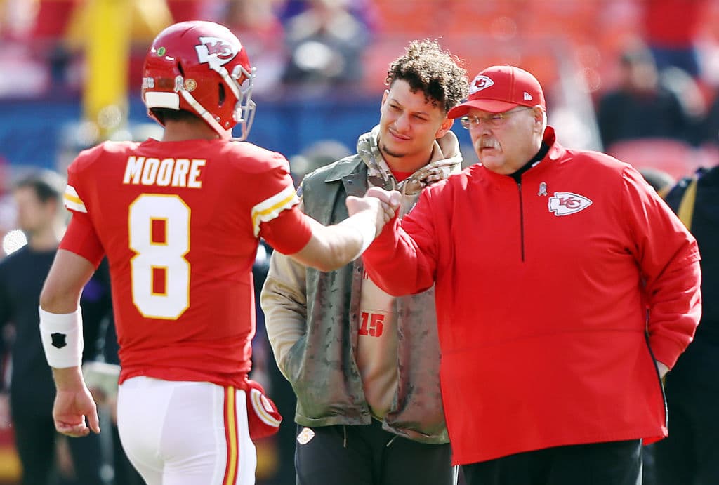 Matt Moore y el head coach Andy Reid se felicitan tras la ofensiva del equipo; Patrick Mahomes observa.