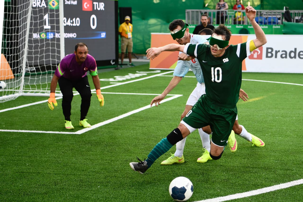Jugadores invidentes luchan por el balón durante partido de fútbol entre los equipos de Brasil y Turquía.