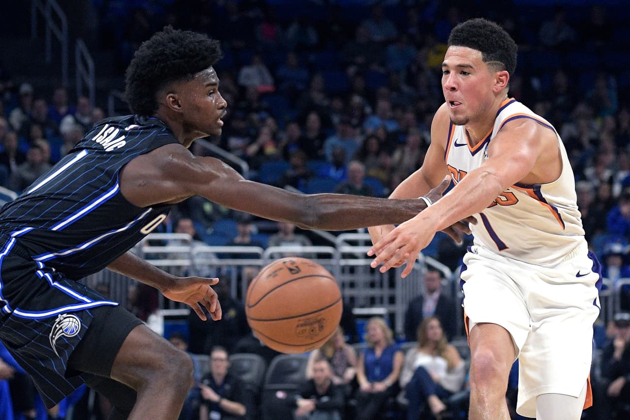 Con 35 puntos, siete rebotes y ocho asistencias, Devin Booker (derecha) lideró a los Phoenix Suns al triunfo 122-120 sobre Orlando Magic en tiempo extra.