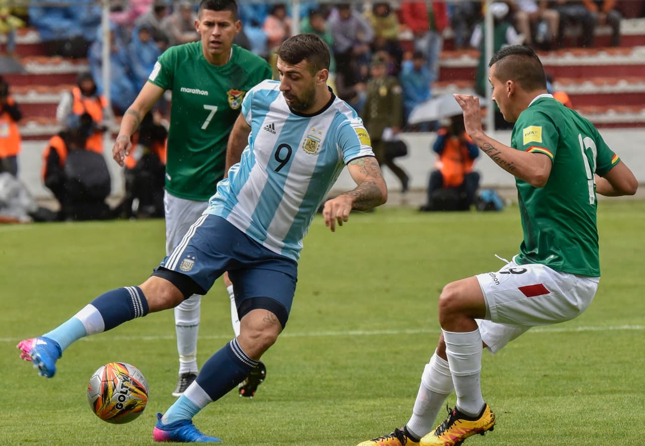 Argentina's Lucas Pratto (C) vies for the ball with Bolivia's Ruben Cordano (R) during their 2018 FIFA World Cup qualifier football match in La Paz, on March 28, 2017. / AFP PHOTO / AIZAR RALDES (Photo credit should read AIZAR RALDES/AFP/Getty Images)