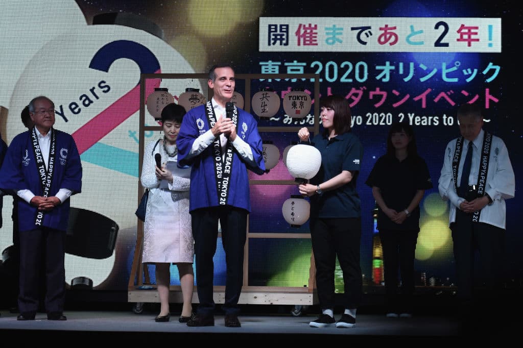 Al centro en la imagen, el alcalde de la ciudad de Los Ángeles, Eric Garcetti, en el escenario de la ceremonia a dos años de Tokio 2020. En 2028 LA será sede olímpica por tercera ocasión.