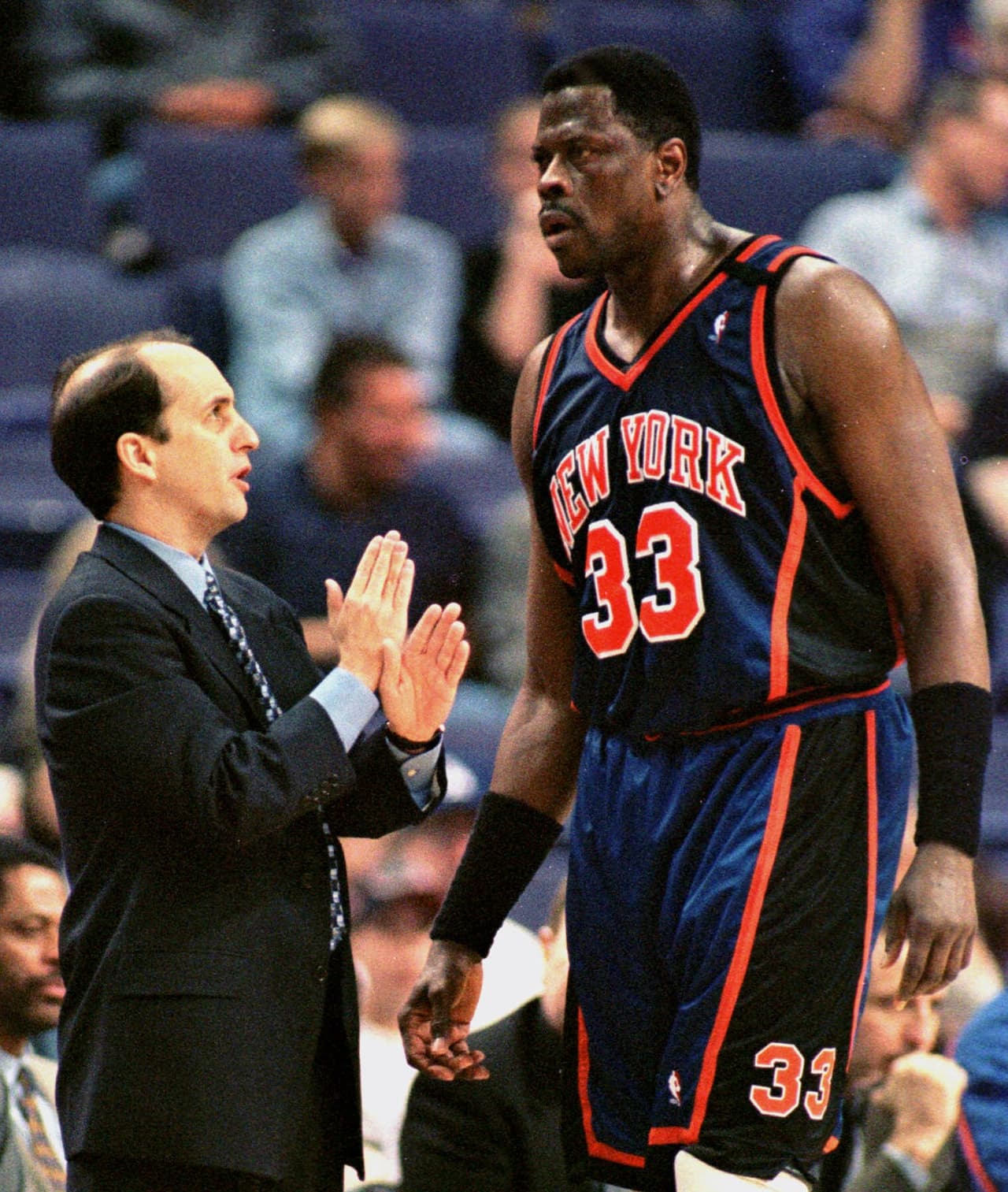 New York Knicks coach Jeff Van Gundy, whose job is considered in jeopardy, talks with center Patrick Ewing, who became only the 12th player in NBA history to reach 20,000 career points and 10,000 career rebounds, during the Friday night, March 26, 1999, game, with the Phoenix Suns in Phoenix. Ewing entered the game needing four rebounds and got them during the first half. (AP Photo/Jack Smith)