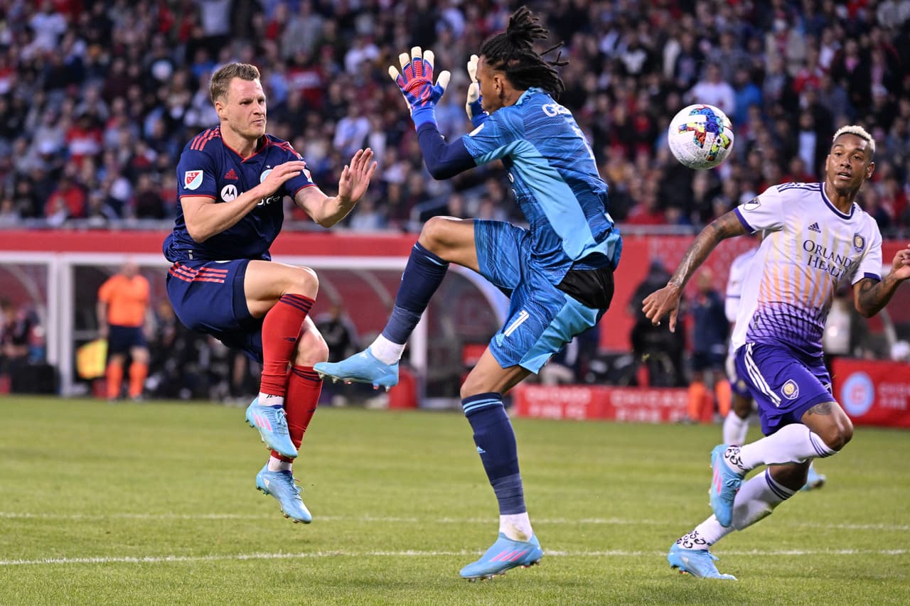 Mar 5, 2022; Chicago, Illinois, USA; Chicago Fire FC midfielder Fabian Herbers (21) prepares to collide with Orlando City SC goalkeeper Pedro Gallese (1) in the first half at Soldier Field. Mandatory Credit: Jamie Sabau-USA TODAY Sports