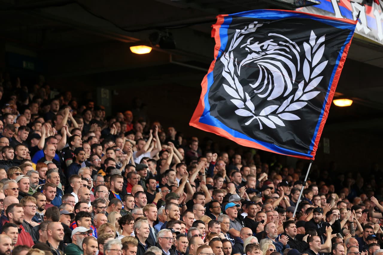 Los aficionados del Crystal Palace ondean la bandera de su equipo.