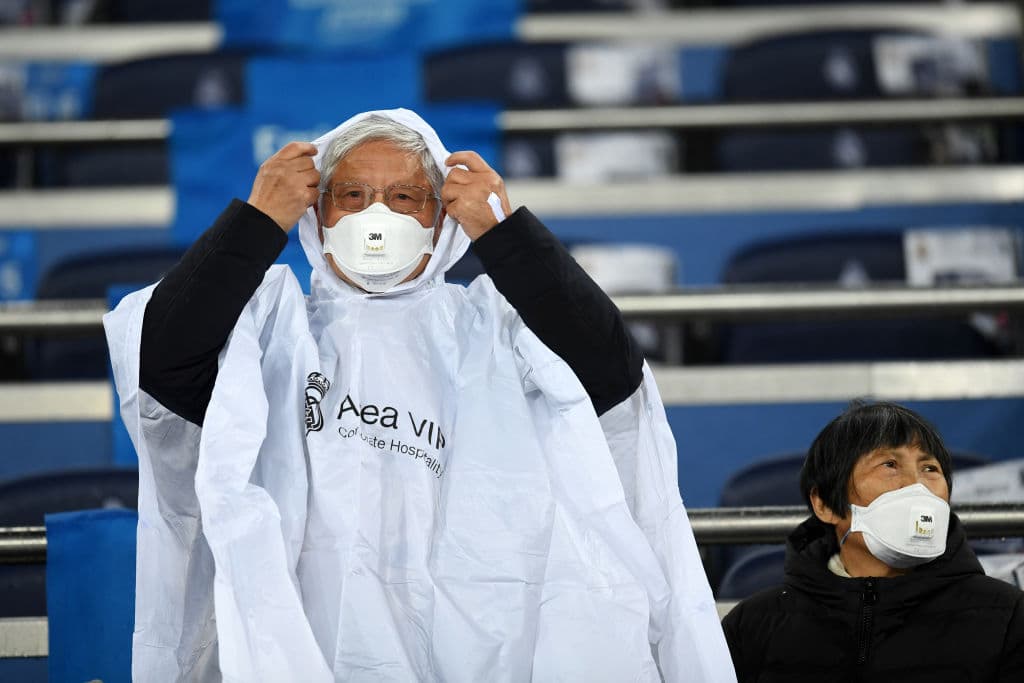 Un adulto mayor se prepara para el juego, protegiendo nariz y boca en las gradas del Bernabéu.
