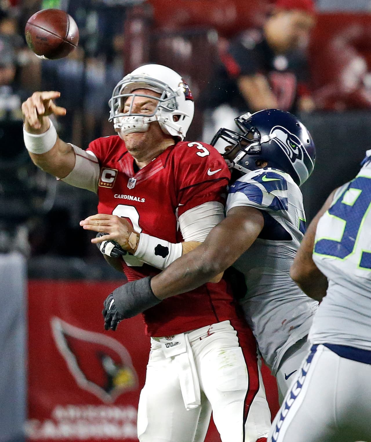 Carson Palmer, QB de los Cadinals,presionado por la línea defensiva de Seattle.