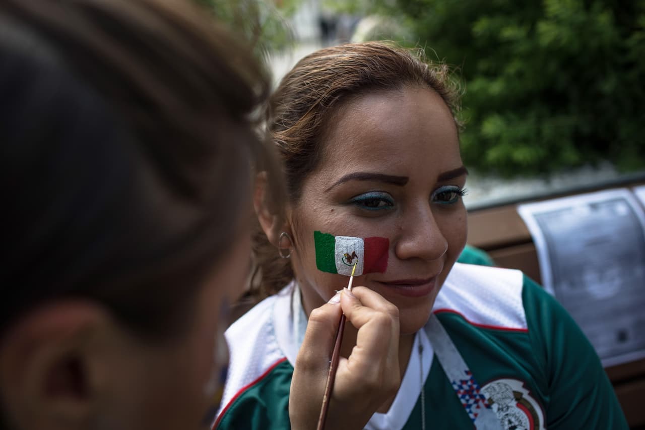 Ekaterinburg (Russian Federation), 27/06/2018.- A Mexican fan gets his country's flag painted on his cheek in the center of Ekaterinburg, Russia, 27 June 2018. Mexico with will face Sweden in their group F preliminary round soccer match of the FIFA World Cup 2018 on 27 June 2018. (Mundial de Fútbol, Suecia, Rusia) EFE/EPA/ROMAN PILIPEY