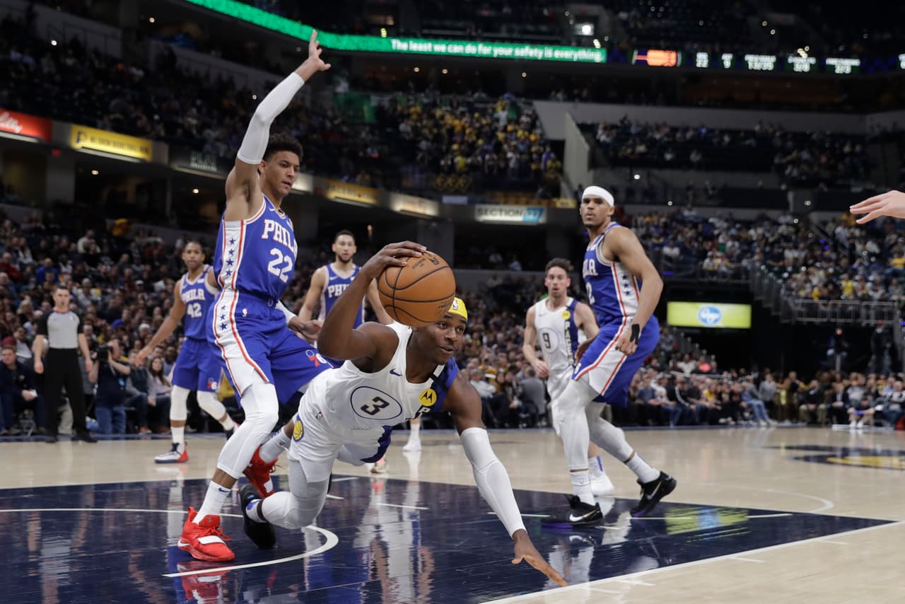 <b>Indiana Pacers 101-95 Philadelphia 76ers.</b> Aaron Holiday cae a la duela pero conserva el balón pese a la mirada de su marcador Matisse Thybulle de los Philadelphia 76ers.