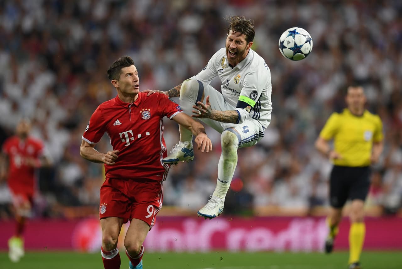 MADRID, SPAIN - APRIL 18: Robert Lewandowski of Bayern Muenchen and Sergio Ramos of Real Madrid battle to win a header during the UEFA Champions League Quarter Final second leg match between Real Madrid CF and FC Bayern Muenchen at Estadio Santiago Bernabeu on April 18, 2017 in Madrid, Spain. (Photo by Matthias Hangst/Bongarts/Getty Images)