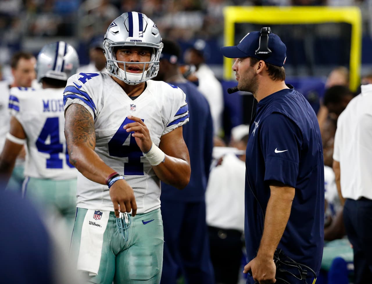 Dallas Cowboys quarterback Dak Prescott (4) throws a pass as he talks with quarterback Tony Romo, right, during an NFL football game against the Philadelphia Eagles on Sunday, Oct. 30, 2016, in Arlington, Texas. (AP Photo/Michael Ainsworth)