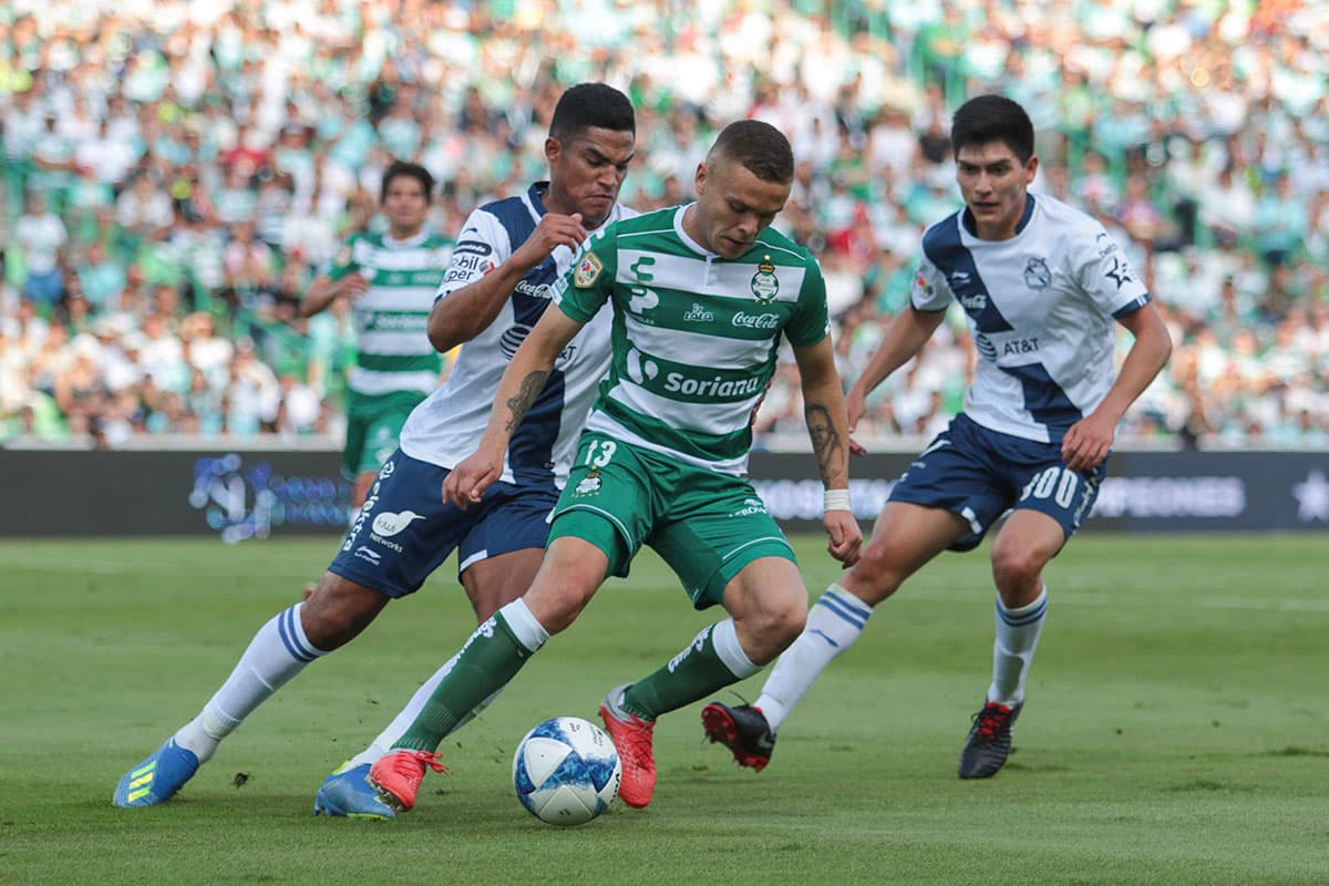 Jonathan Rodríguez (centro), es marcado de cerca por sus rivales.