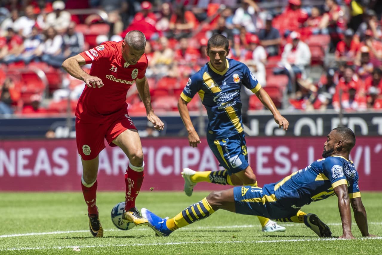 Achilier barre fuerte, pero al balón y desarma el avance de Gigliotti.