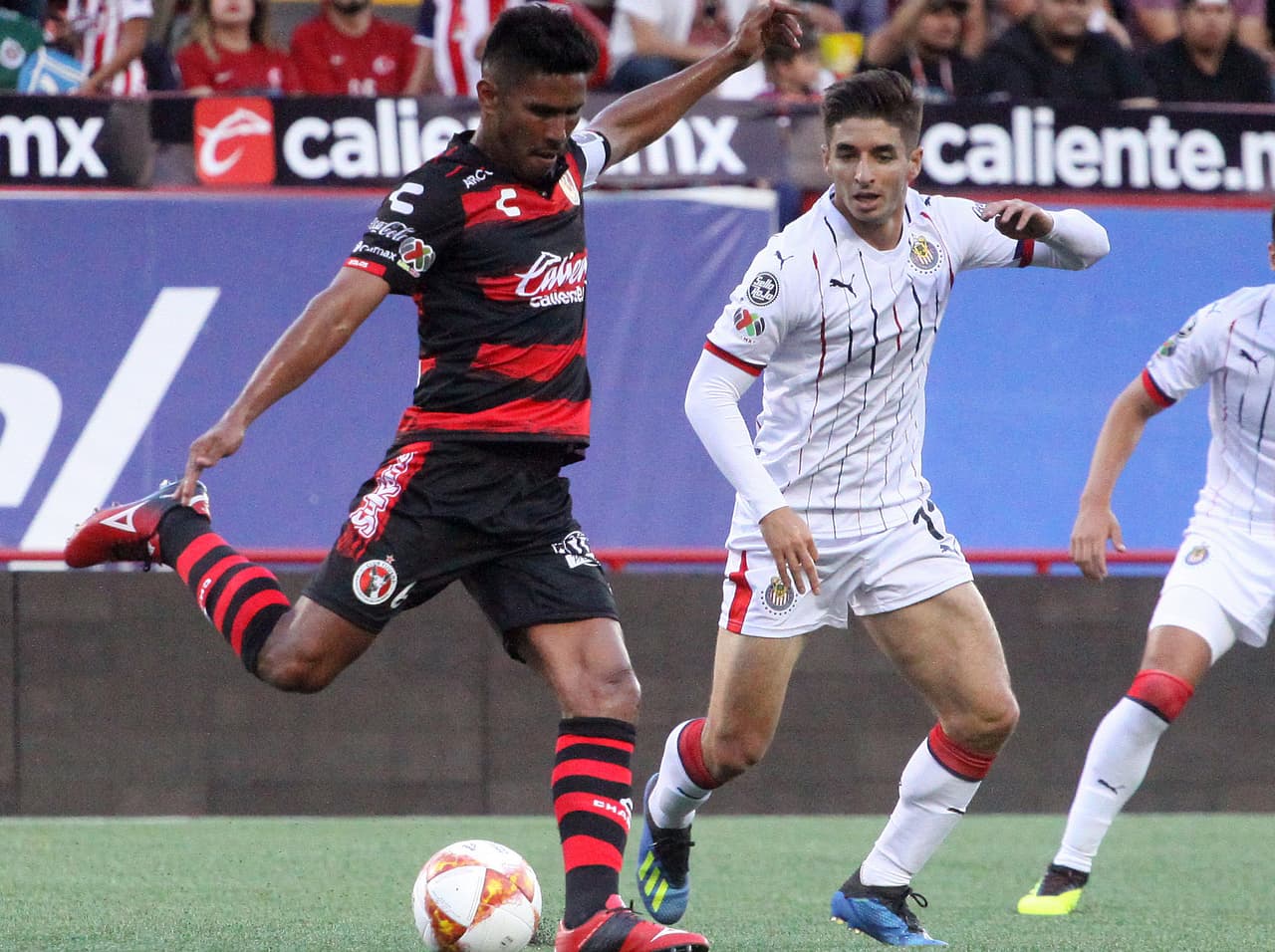 El defensa Juan Valenzuela, de Xolos, despejó la pelota ante una nueva aproximación de Chivas.