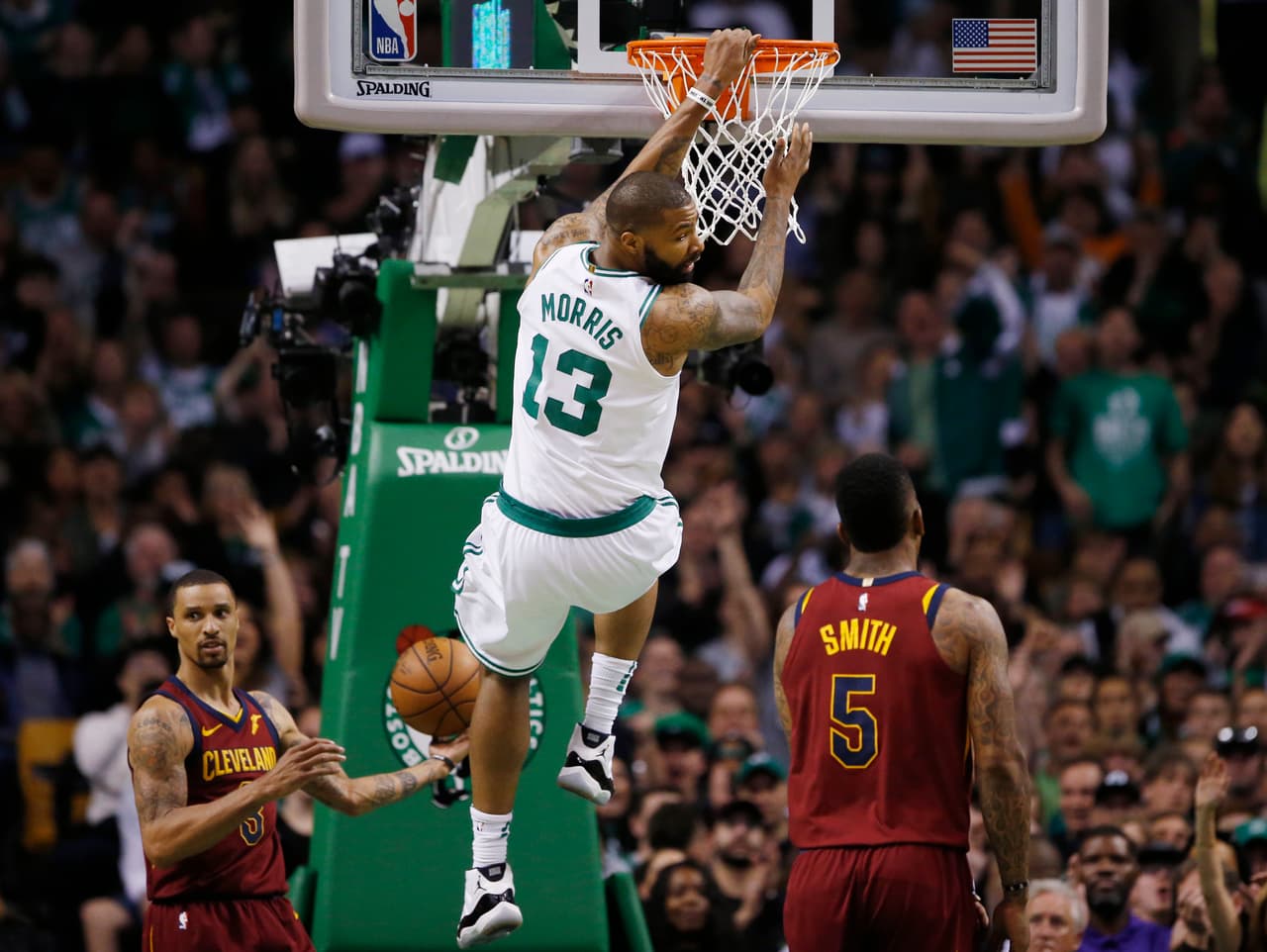 Boston Celtics forward Marcus Morris (13) dunks against Cleveland Cavaliers guards George Hill (3) and JR Smith (5) in the second quarter of Game 1 of the NBA basketball Eastern Conference Finals against the Cleveland Cavaliers, Sunday, May 13, 2018, in Boston. (AP Photo/Michael Dwyer)