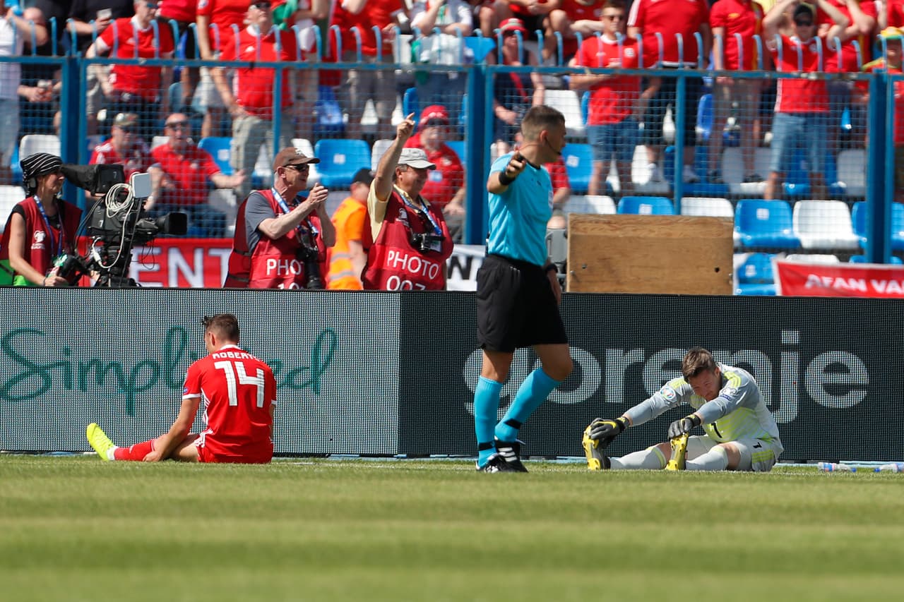 Wayne Hennessey no pudo evitar la caída de su arco y lamentaba con su defensor la dura situación.