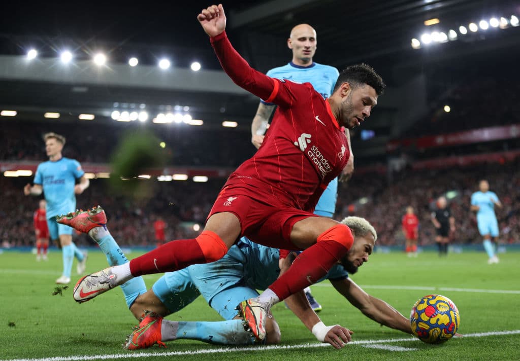 LIVERPOOL, ENGLAND - DECEMBER 16: Alex Oxlade-Chamberlain of Liverpool is challenged by Joelinton of Newcastle United during the Premier League match between Liverpool and Newcastle United at Anfield on December 16, 2021 in Liverpool, England. (Photo by Clive Brunskill/Getty Images)