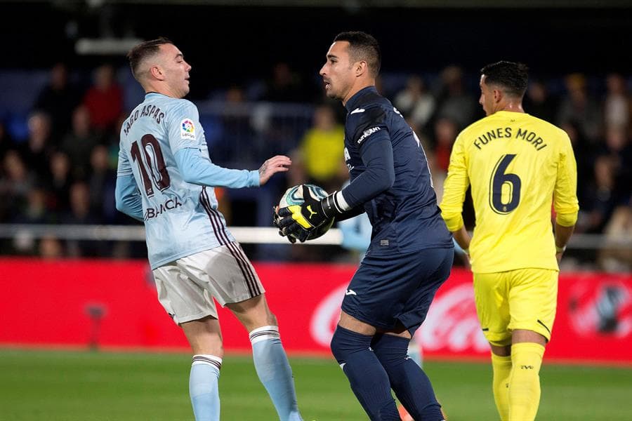 El portero del Villarreal, Sergio Asenjo, atrapa el balón ante el delantero del Celta, Iago Aspas.