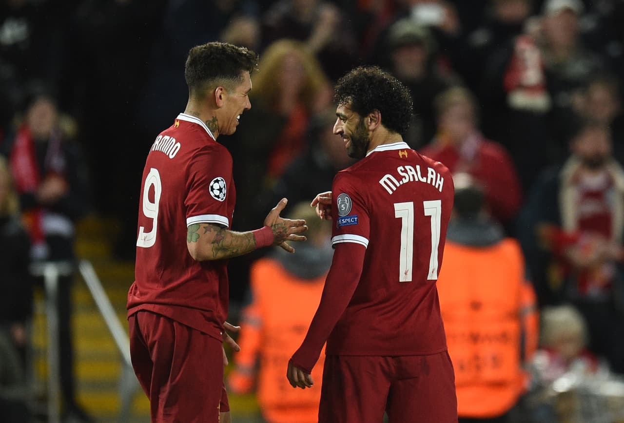 Liverpool's Brazilian midfielder Roberto Firmino (L) celebrates with Liverpool's Egyptian midfielder Mohamed Salah after scoring their fourth goal during the UEFA Champions League first leg semi-final football match between Liverpool and Roma at Anfield stadium in Liverpool, north west England on April 24, 2018. (Photo by Oli SCARFF / AFP) (Photo credit should read OLI SCARFF/AFP/Getty Images)