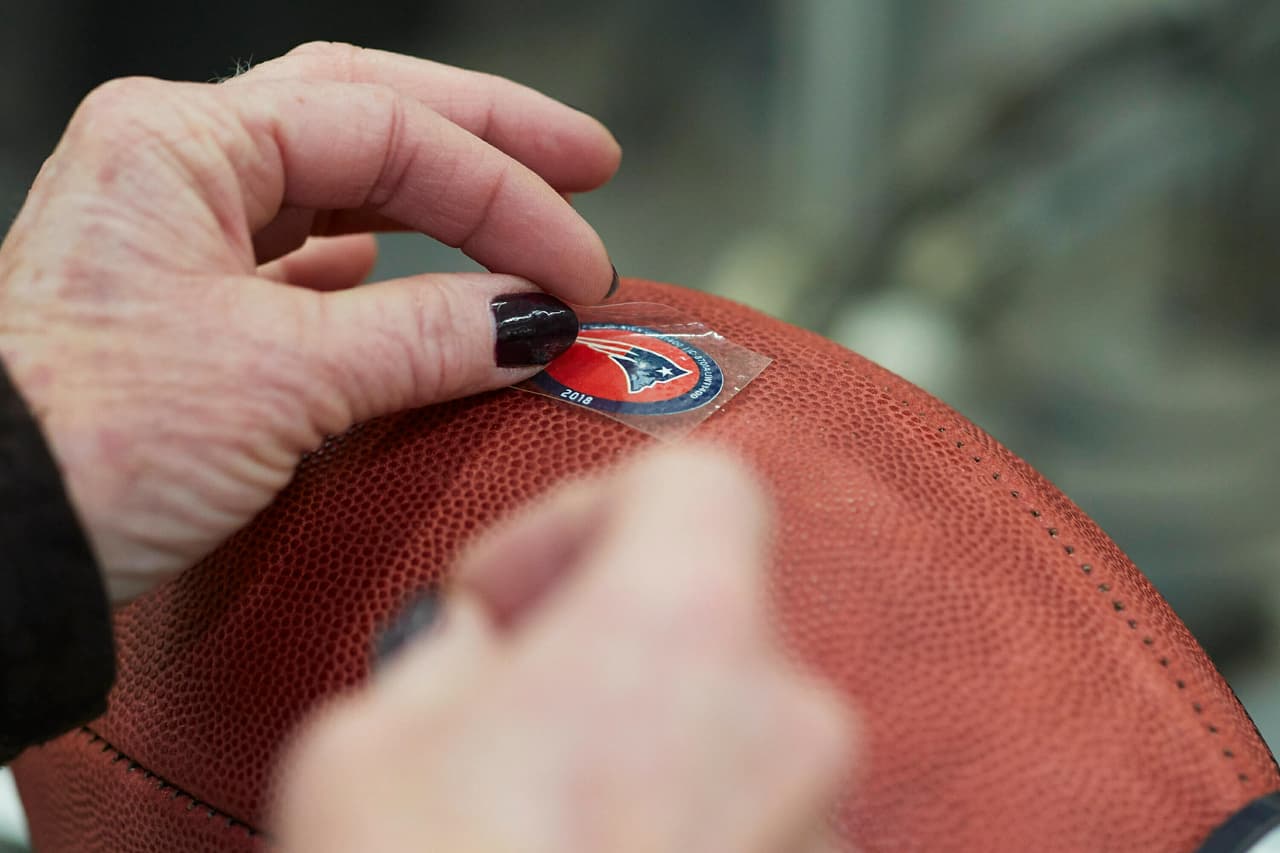 Otorgando el toque final a un balón con el sticker de los Patriots.