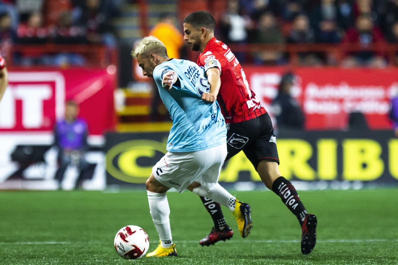 José Rivero trata de robarle la pelota a Rubens Sambueza, pero la experiencia del argentino le rinde para lograr salir con el balón controlado.