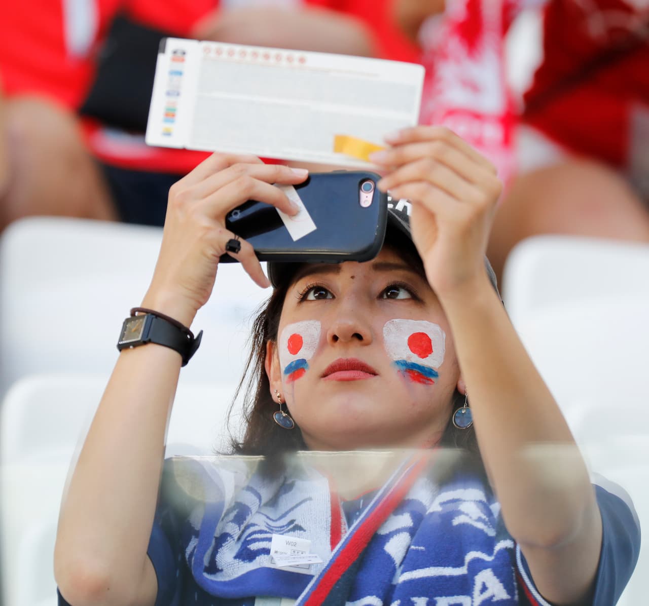 A fan of the Japanese team takes a picture of her ticket prior to the group H match between Japan and Poland at the 2018 soccer World Cup at the Volgograd Arena in Volgograd, Russia, Thursday, June 28, 2018. (AP Photo/Eugene Hoshiko)
