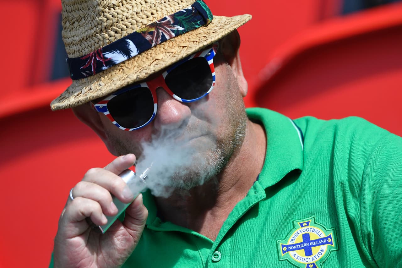 Disfrutando del fútbol y de un puro.