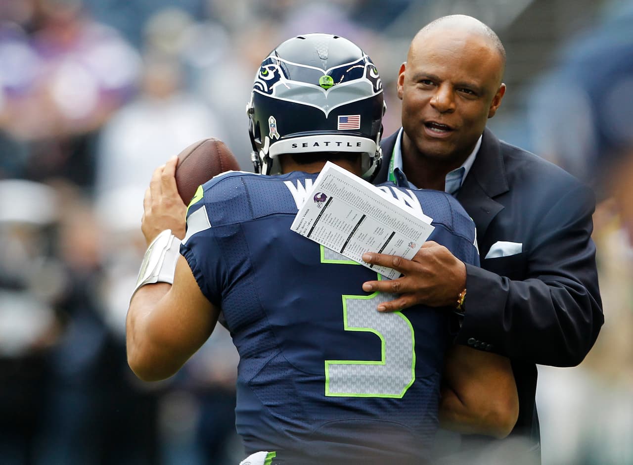 Seattle Seahawks quarterback Russell Wilson, left, is greeted by Seahawks' legend Warren Moon during warm-ups before an NFL football game against the Minnesota Vikings, Sunday, Nov. 4, 2012, in Seattle. (AP Photo/Elaine Thompson)