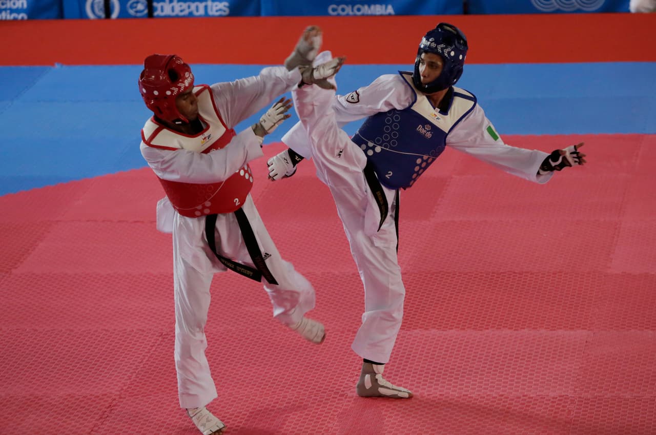 El mexicano César Rodríguez (derecha) en su combate de taekwondo contra el venezolano Cleiver Olaizola (izquierda).