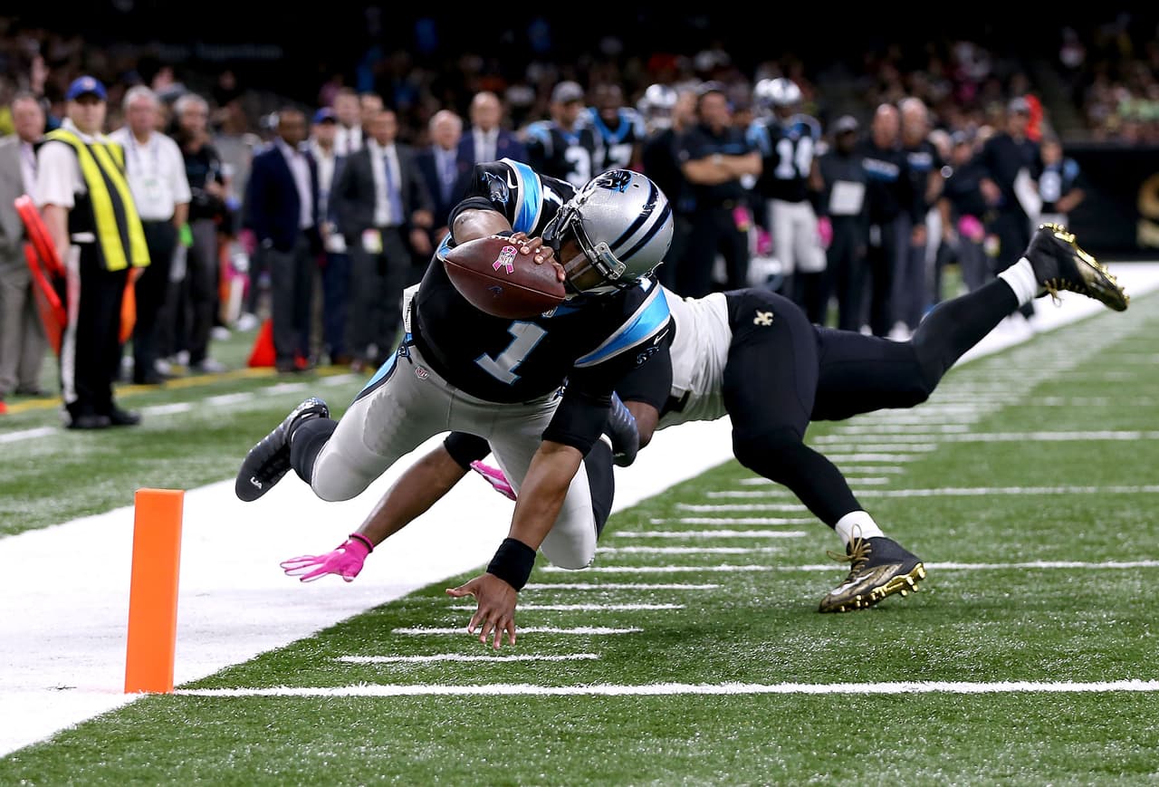 A pesar del gran esfuerzo, Cameron Jordan 94 de los Santos de Nueva Orleans no puede impedir el touchdown de Cam Newton para las Panteras de Carolina en el Mercedes-Benz Superdome en el Nueva Orleans, Louisiana. A pesar de eso, los Santos ganaron 41-38.