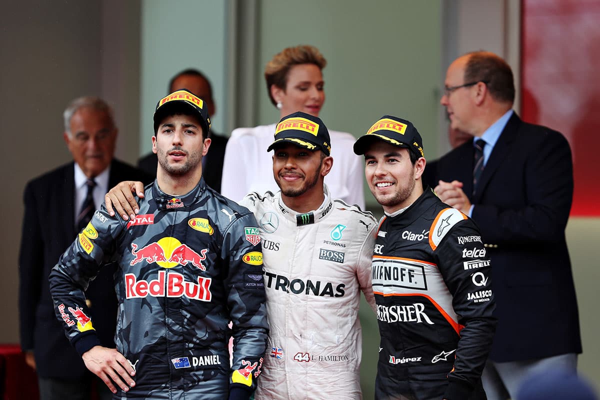 Daniel Ricciardo (izquierda) y Lewis Hamilton (centro) en el podio con Checo Pérez en el Principado de Mónaco.