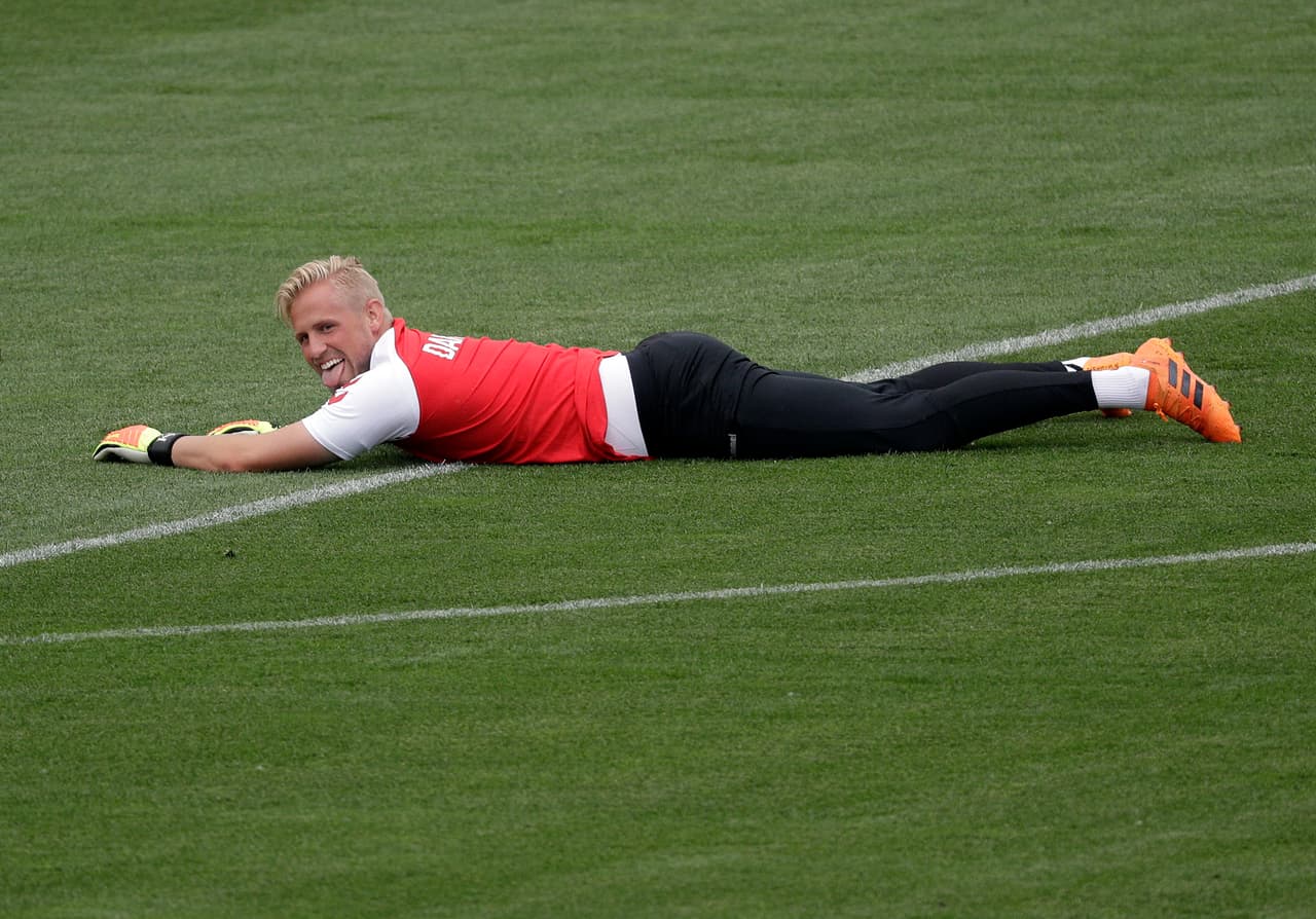 El guardameta de la selección de Dinamarca Kasper Schmeichel, yace en el piso mientras ve a sus compañeros en el entrenamiento final previo a enfrentarse a Croacia.