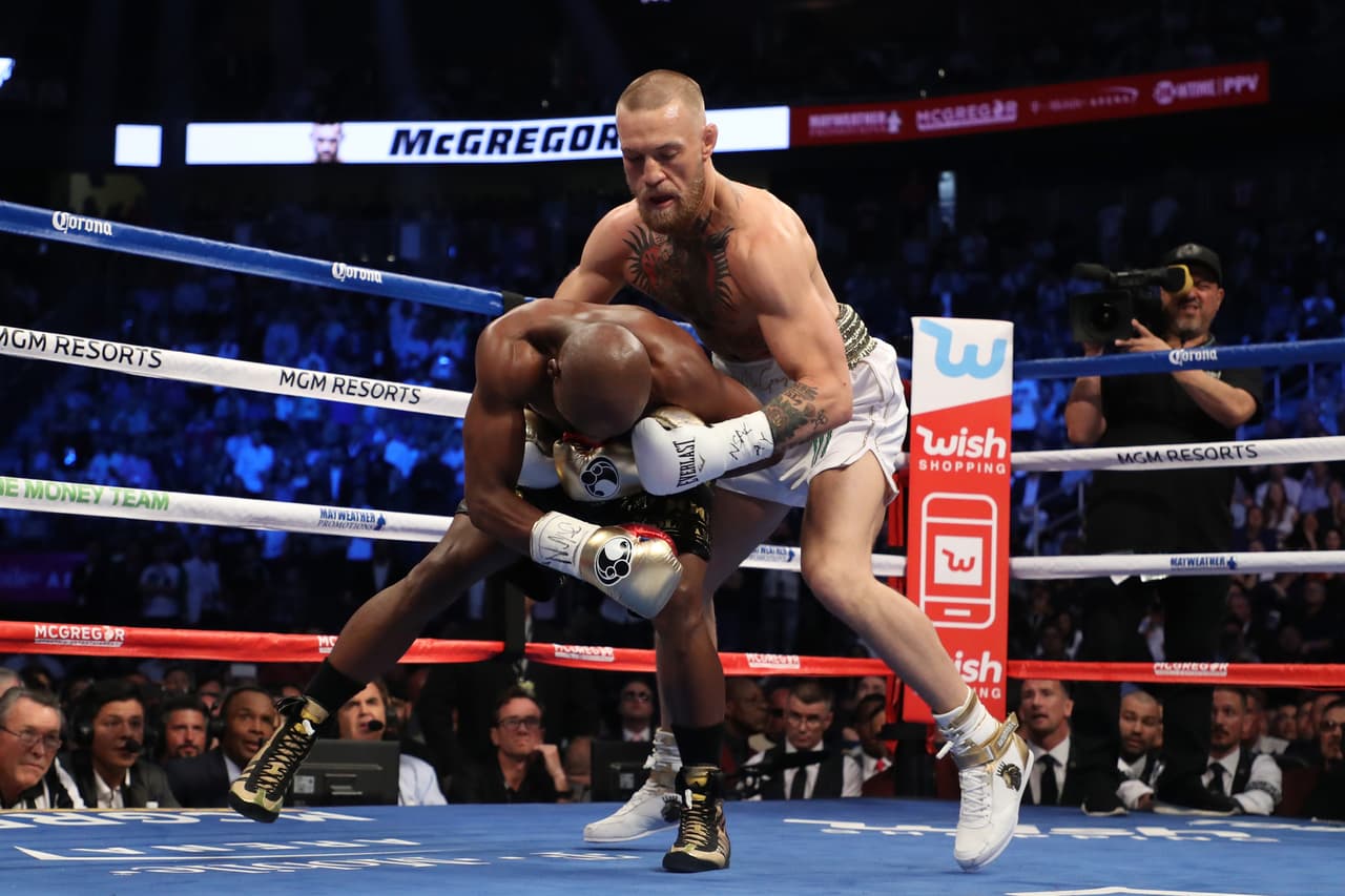 LAS VEGAS, NV - AUGUST 26: (R-L) Conor McGregor throws a punch at Floyd Mayweather Jr. during their super welterweight boxing match on August 26, 2017 at T-Mobile Arena in Las Vegas, Nevada. (Photo by Christian Petersen/Getty Images)