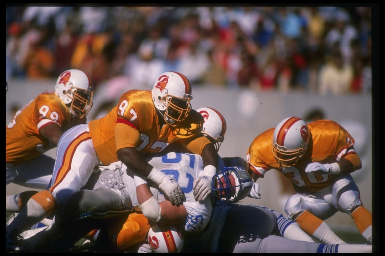 18 Dec 1988: Defensive lineman Shawn Lee of the Tampa Bay Buccaneers (center) tackles a Detroit Lions player during a game at Tampa Stadium in Tampa, Florida. The Buccaneers won the game, 21-10. Mandatory Credit: Allen Dean Steele /Allsport