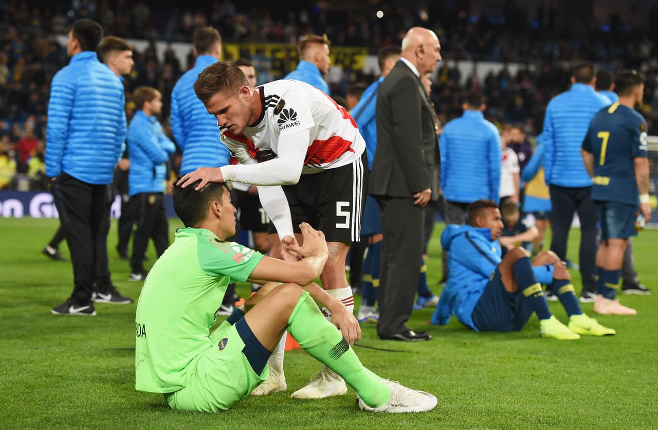 MADRID, SPAIN - DECEMBER 09: Bruno Zuculini of River Plate consoles Esteban Andrada of Boca Juniors following River Plate's victory in the second leg of the final match of Copa CONMEBOL Libertadores 2018 between Boca Juniors and River Plate at Estadio Santiago Bernabeu on December 9, 2018 in Madrid, Spain. Due to the violent episodes of November 24th at River Plate stadium, CONMEBOL rescheduled the game and moved it out of Americas for the first time in history. (Photo by Denis Doyle/Getty Images)