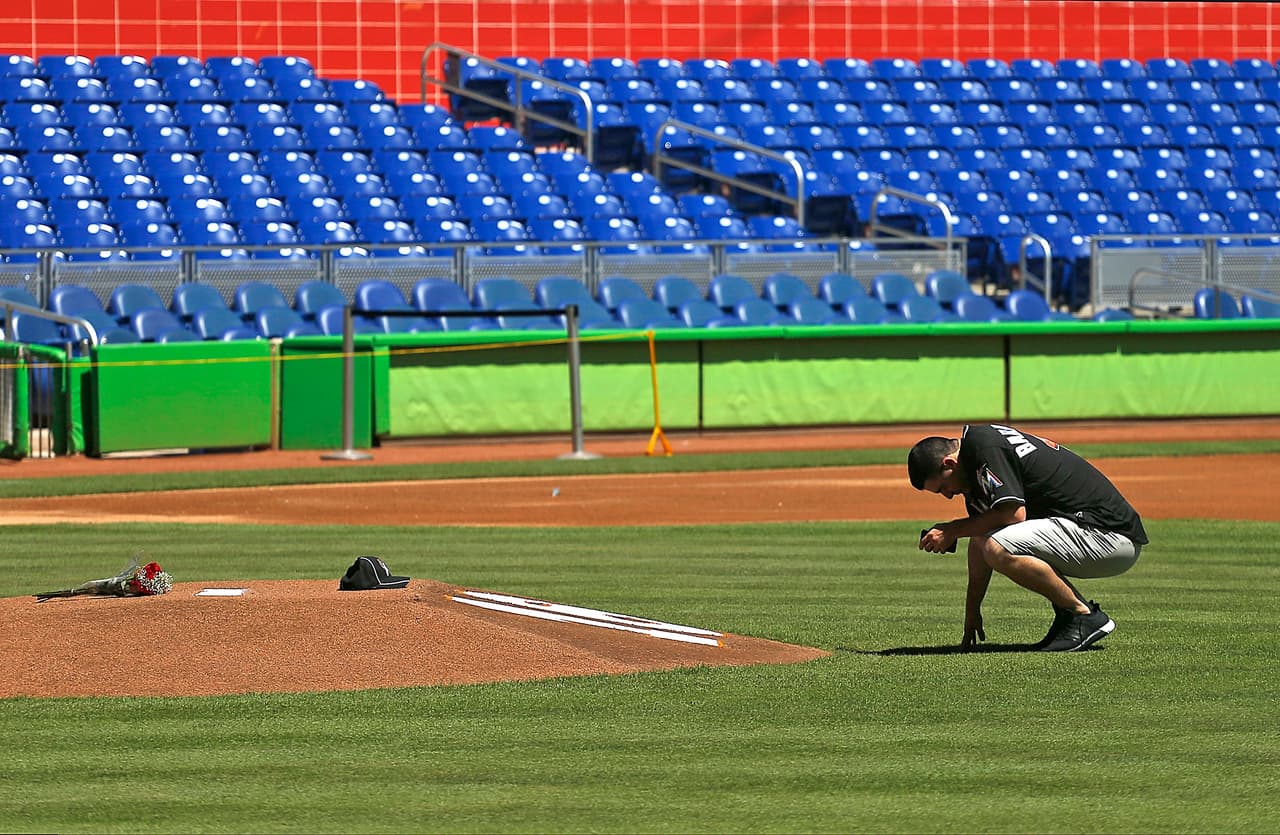 El pitcher de los Marlins Kyle Barracl, compañero de José Fernández, en un momento de reflexión frente al montículo de lanzamiento del Marlins Park, donde está escrito el número 16 en honor al jugador que murió en la madrugada.