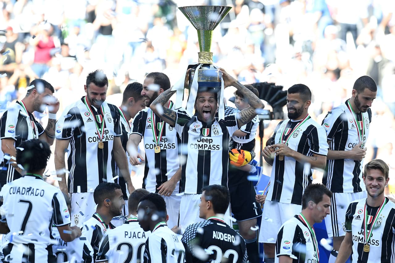 TURIN, ITALY - MAY 21: Daniel Alves of Juventus FC celebrates with the trophy after the beating FC Crotone 3-0 to win the Serie A Championships at the end of the Serie A match between Juventus FC and FC Crotone at Juventus Stadium on May 21, 2017 in Turin, Italy. (Photo by Valerio Pennicino/Getty Images)