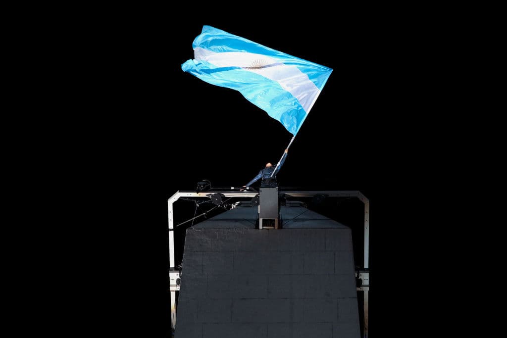 En la cima del Obelisco la bandera de Argentina en uno de los actos centrales de la ceremonia inaugural.