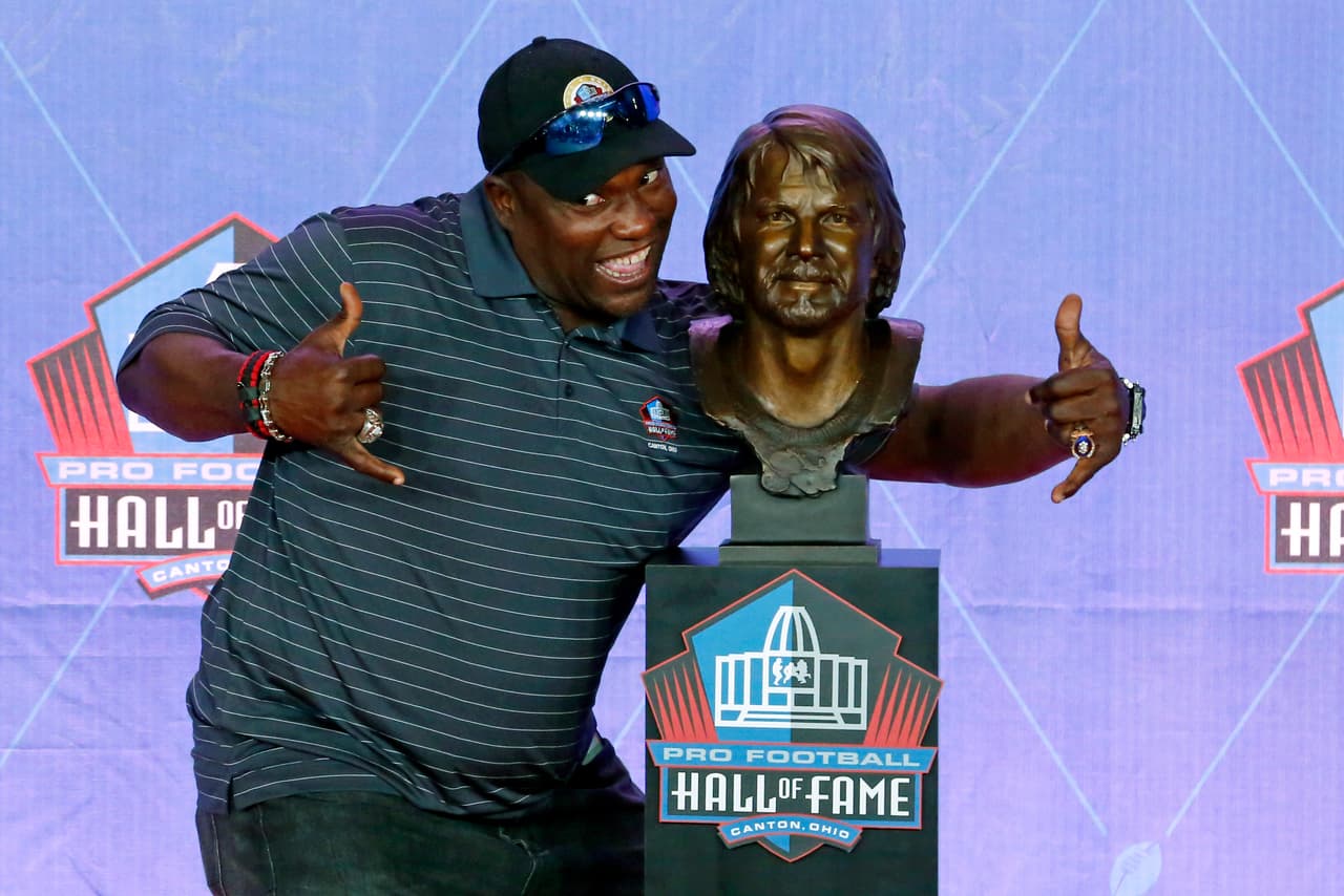 Former NFL player Warren Sapp poses with the bust of quarterback Ken Stabler during an induction ceremony at the Pro Football Hall of Fame, Saturday, Aug. 6, 2016, in Canton, Ohio. (AP Photo/Gene J. Puskar)