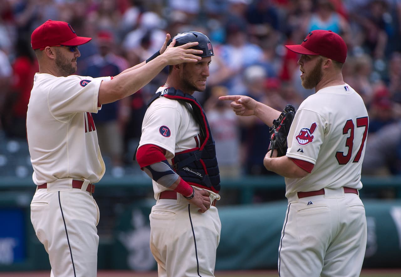 Ryan Raburn de los Cleveland Indians se comporta como un verdadero compañero al acomodarle el casco al cátcher Yan Gomes luego de una jugada brava. Cody Allen señala la forma correcta del trabajo en equipo.